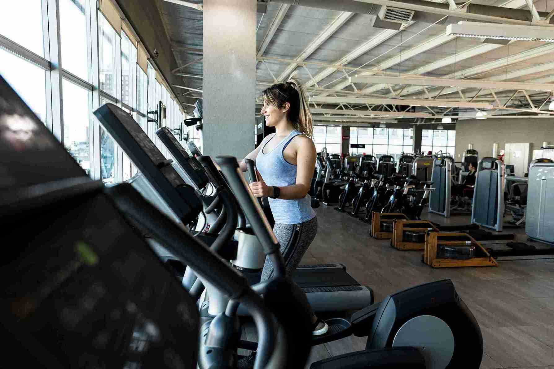 fitness-girl-using-elliptical-trainer_11zon