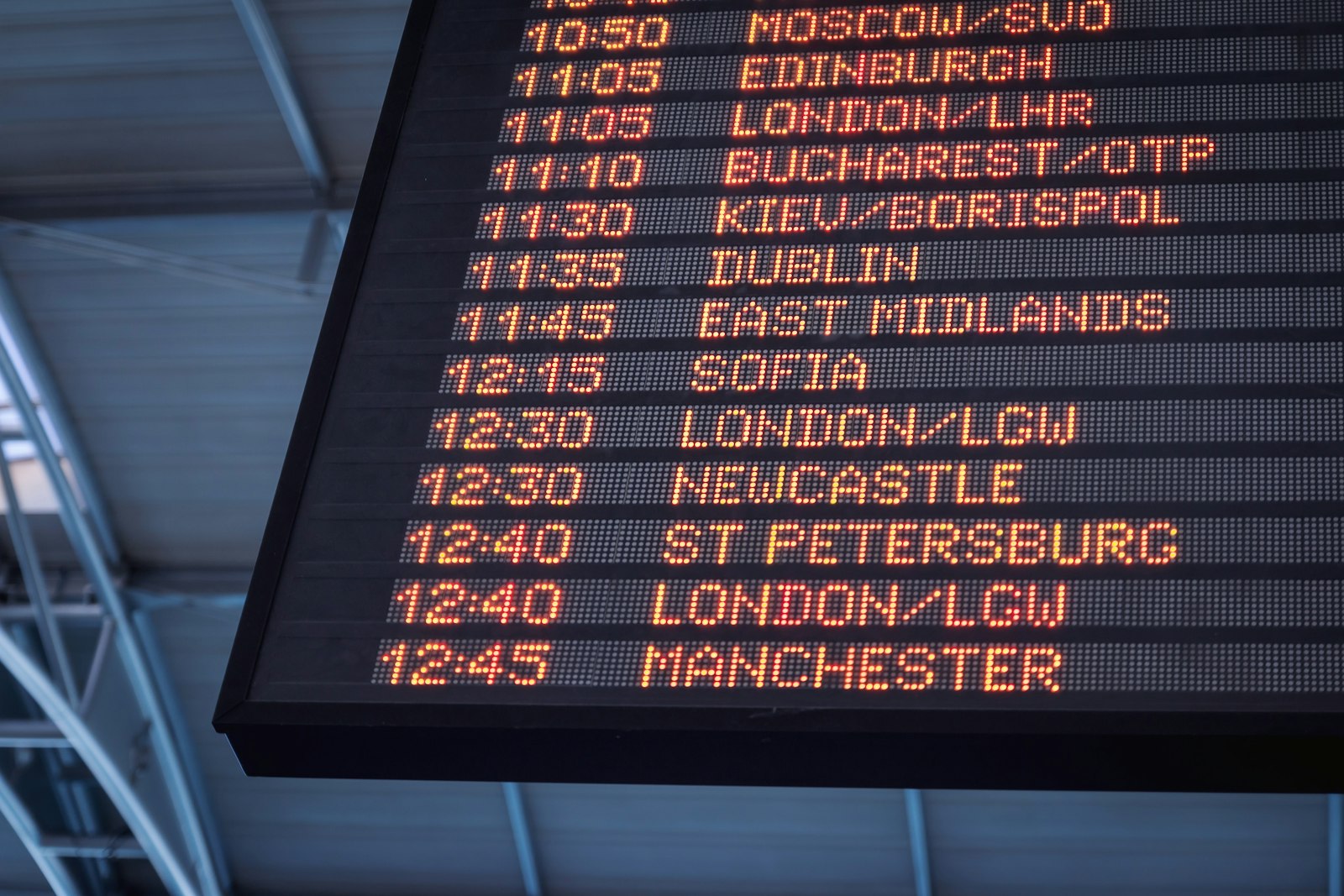 Airport departure board representing the long connecting journey from Canada to Mangalore