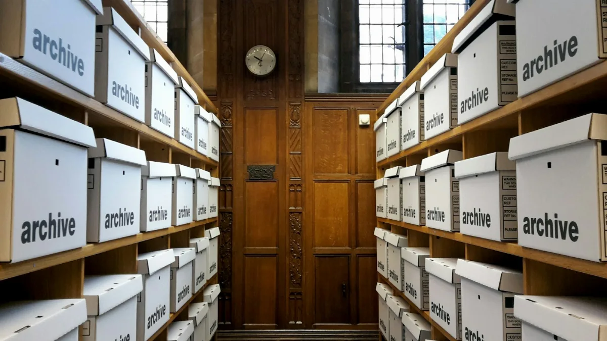 Rows of white archive boxes on wooden shelves for safe storage