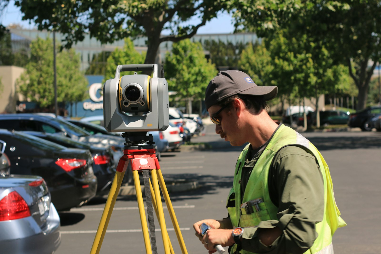 Surveyor using a theodolite representing BDA-approved plots in Bangalore under 50 lakhs
