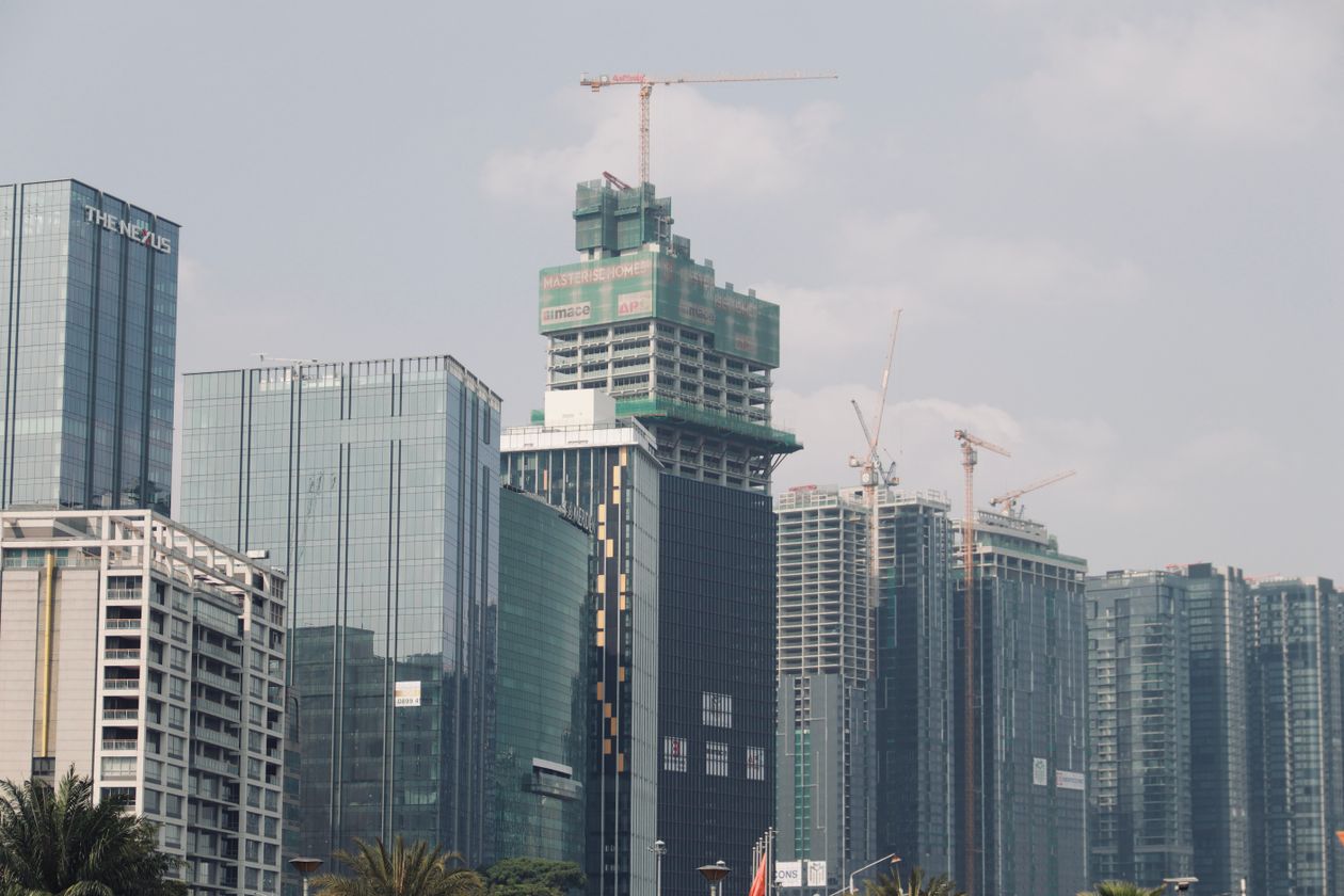 Construction cranes over an urban skyline under development