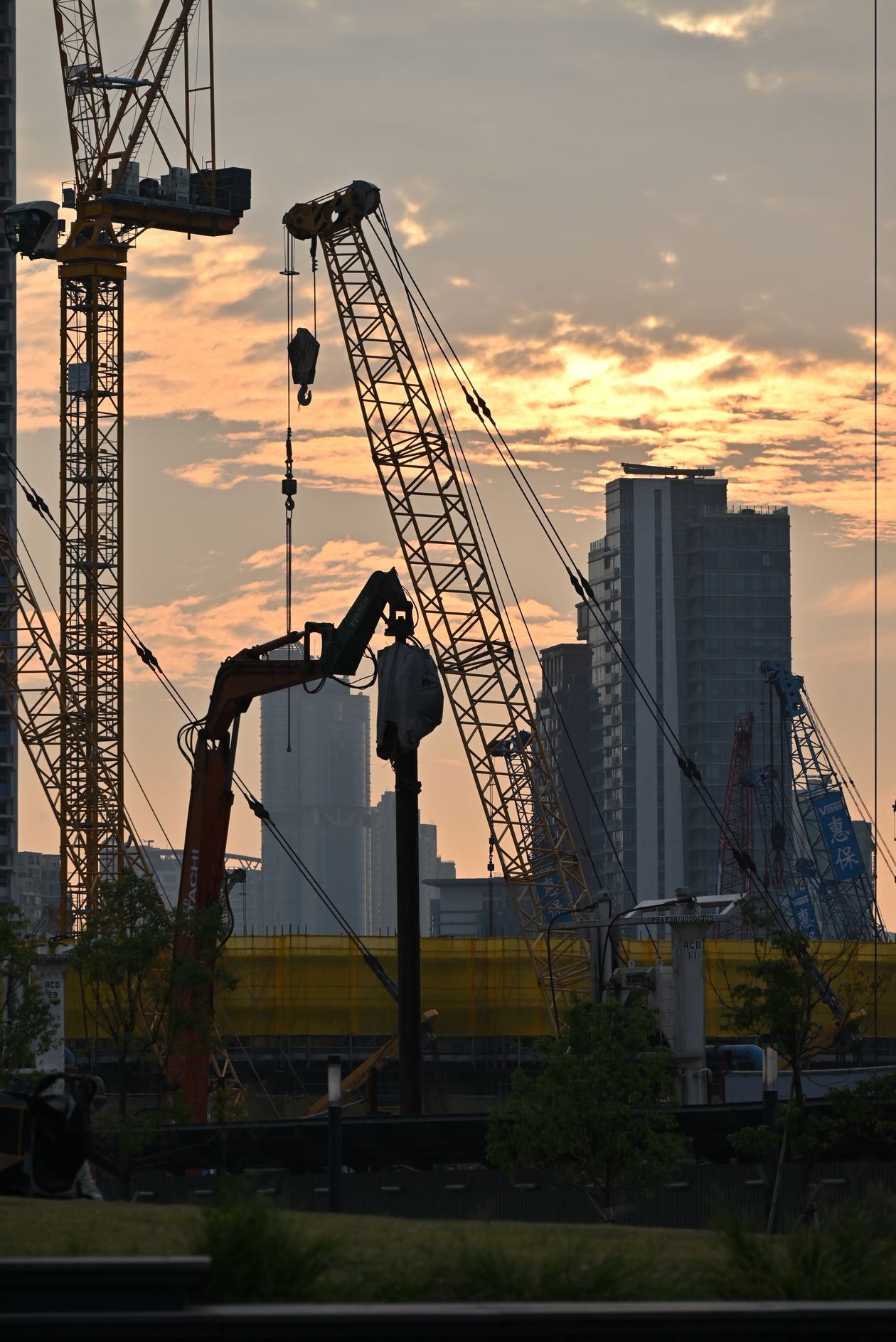 Urban construction site with cranes at dusk