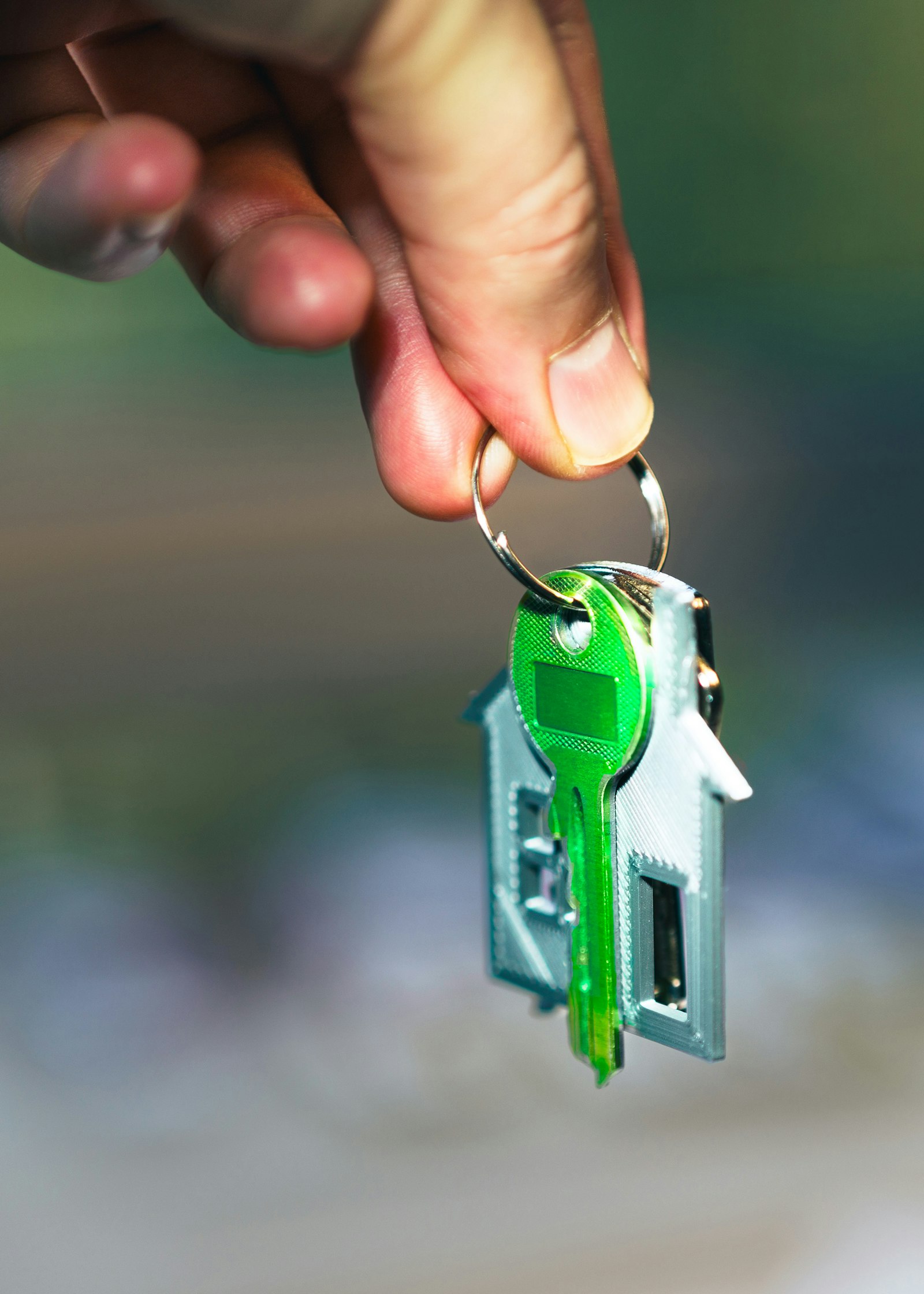 Hand holding a house key representing the building completion certificate process in Karnataka