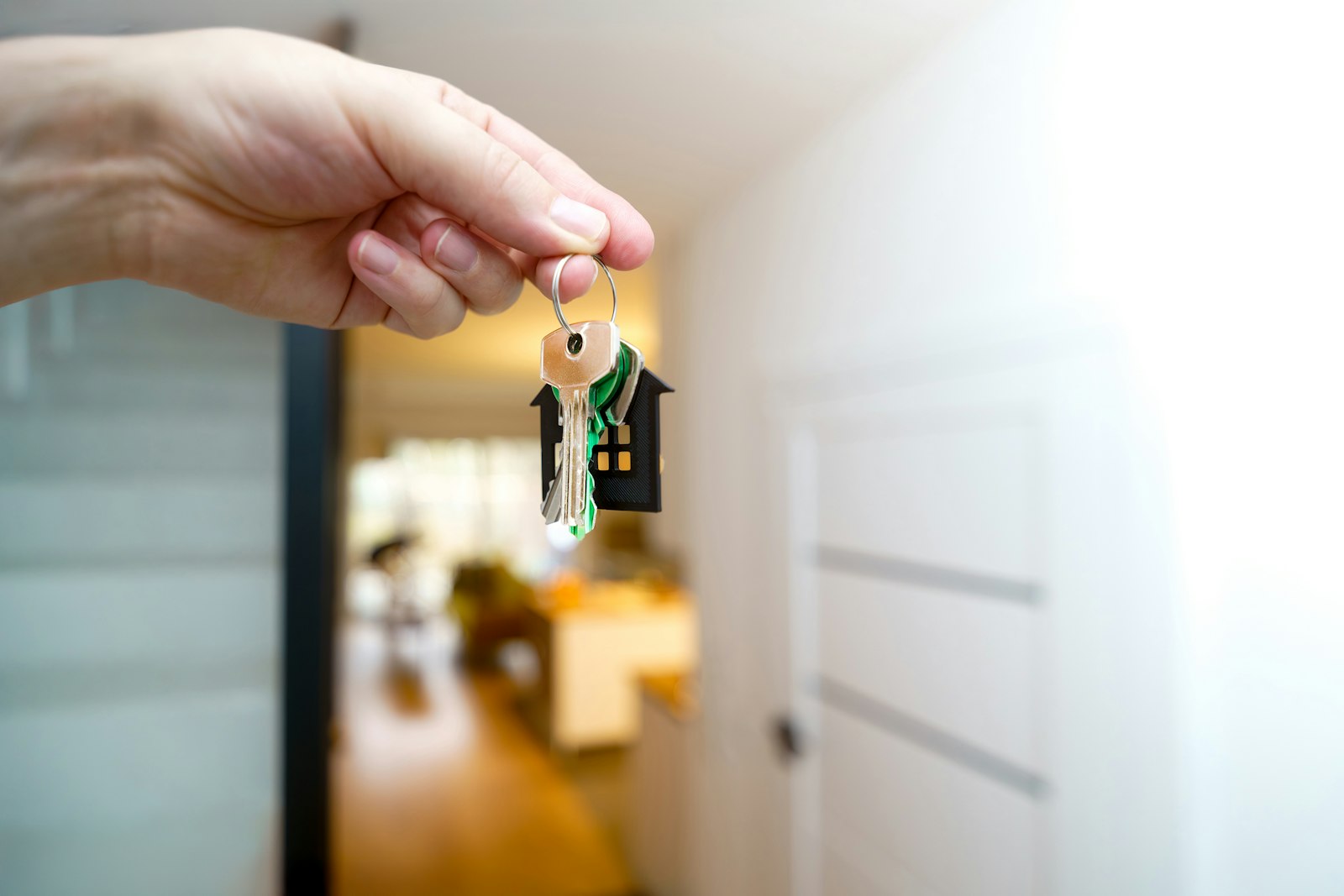 Person holding house keys representing Form 9 vs Form 11 and e-Swathu property registration in Karnataka