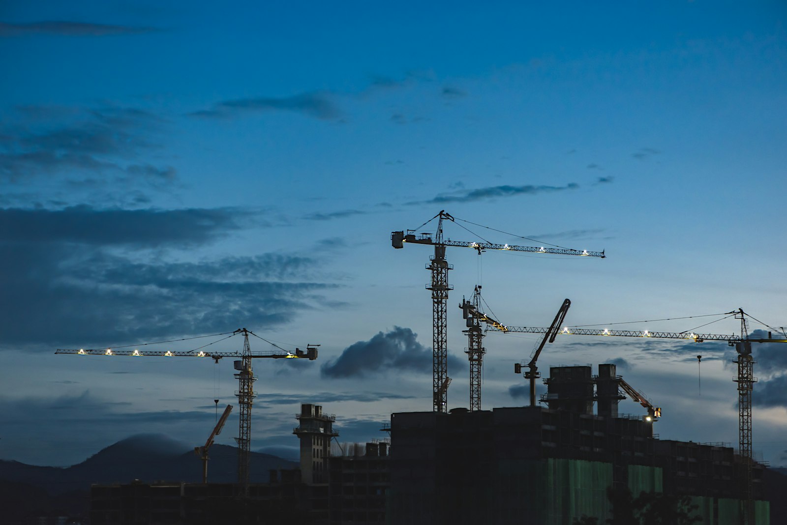 Cranes above buildings representing Jigani real estate property rates and investment insights