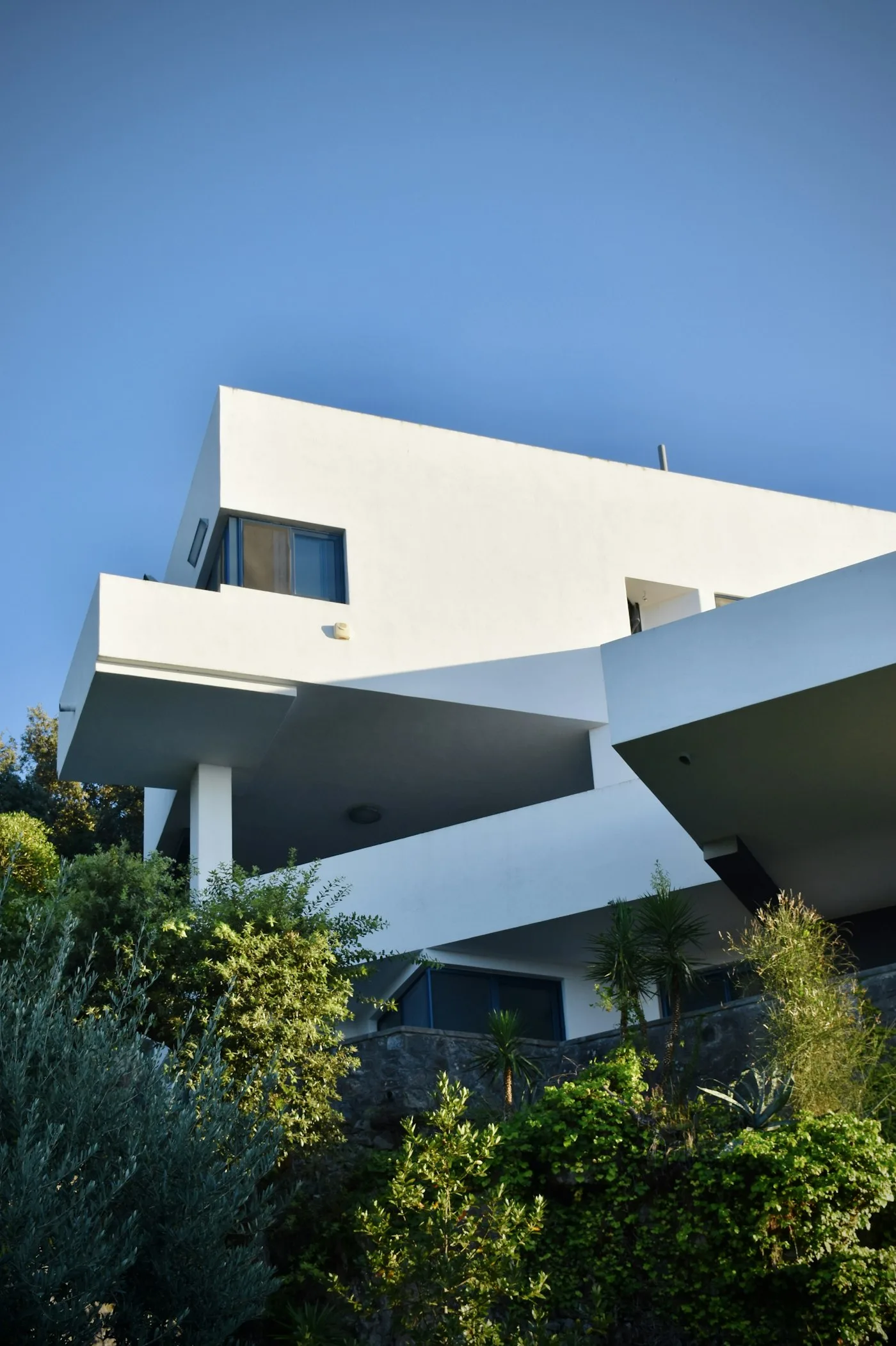 White concrete building near green trees