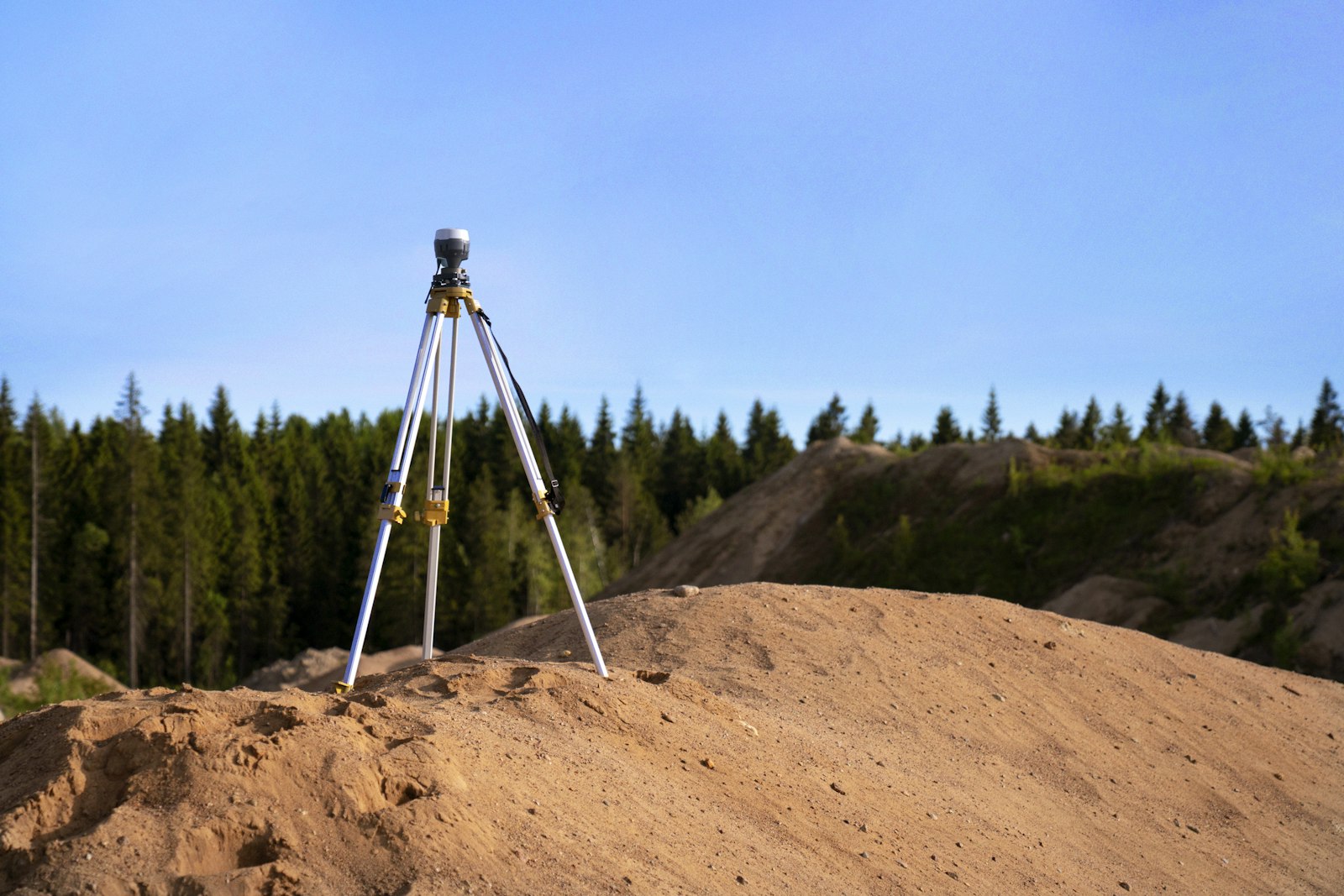 Surveying tripod on a rock representing top mistakes first time plot buyers make in Bangalore