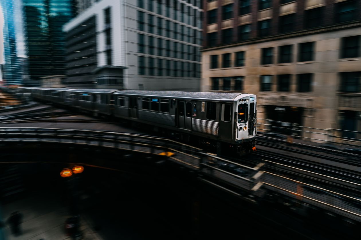 Metro train on elevated tracks moving past downtown high-rises