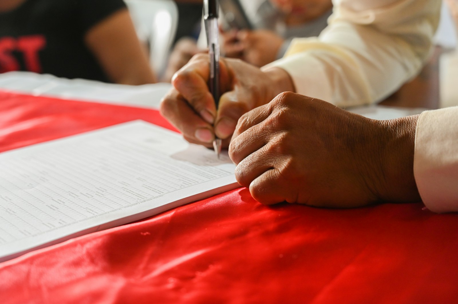 Person writing on paper representing NRI buying property in Bangalore 2026 FEMA, RERA and e-Khata