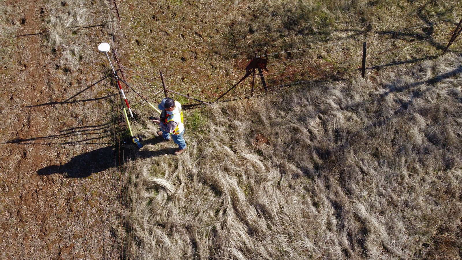 Surveyor climbing terrain representing resale plots versus new plots comparison in Bangalore