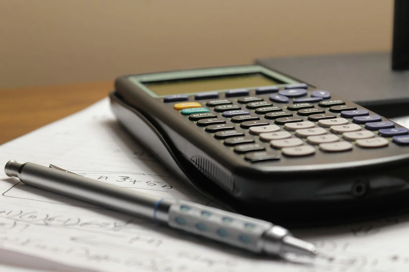 Calculator and pen on a sheet of paper