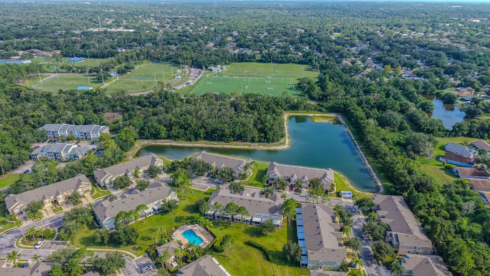 Aerial view of a residential complex with a pool and sports fields used as an illustration