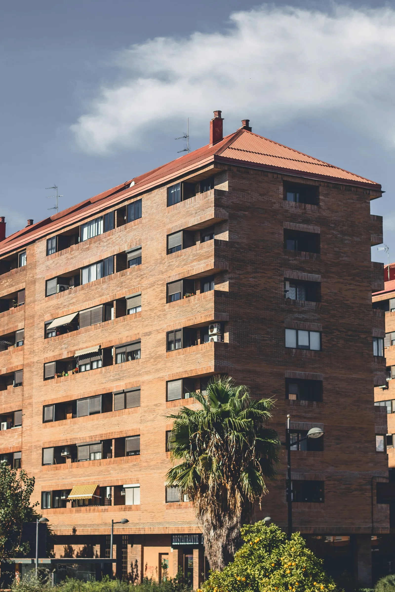Tall residential block beside a green park used as an illustration